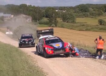 Ott Tänak ja Martin Järveoja reklaambännerit auto küljest eemaldamas